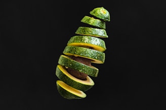 Frozen avocado slices neatly arranged on a white plate with a soft background.