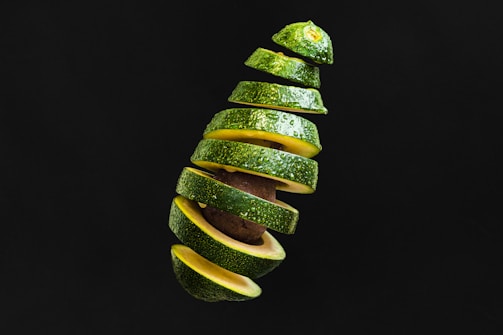 Frozen avocado slices neatly arranged on a white plate with a soft background.