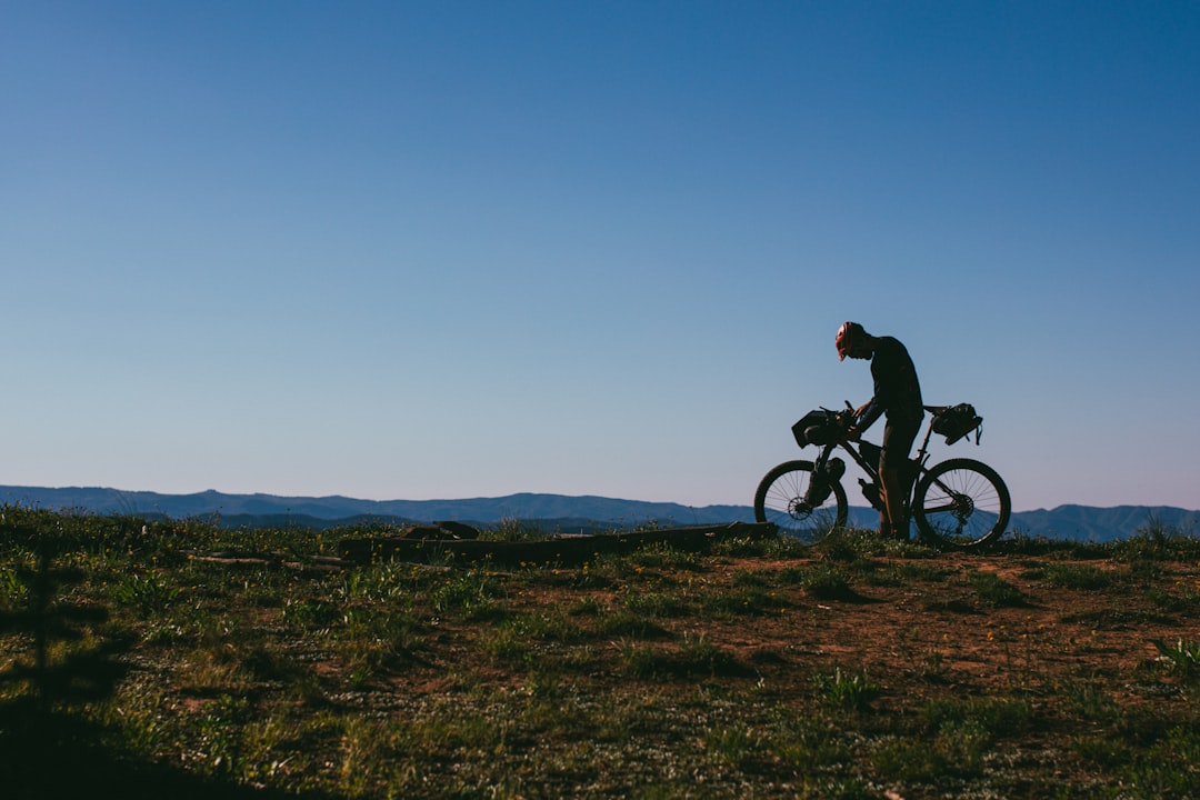 man riding bicycle on green grass field during daytime