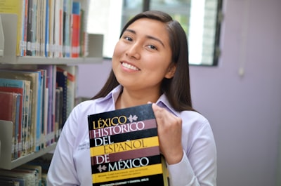 woman in white long sleeve shirt holding book pueblo revival google meet background