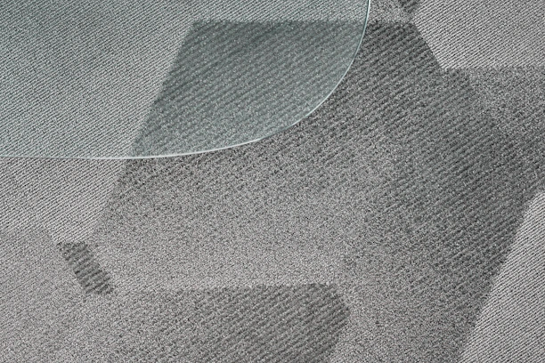 Before and after image showing a deeply cleaned carpet in a modern Geneva living room.