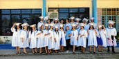 Group of students in white coats smiling outside the institute building.