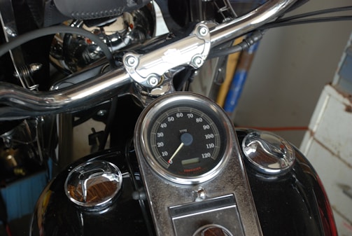 Close-up of a motorcycle dashboard with illuminated speedometer.