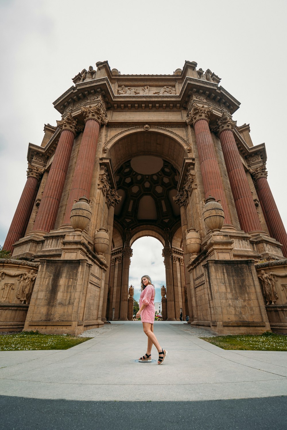 woman in white dress standing near brown concrete building during daytime