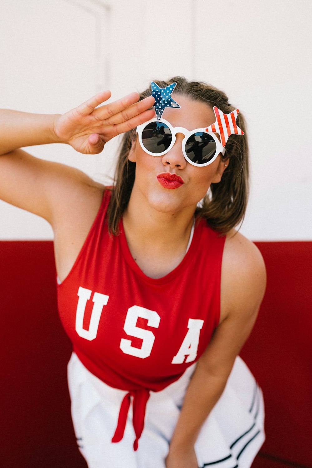 woman in red and white tank top wearing white framed sunglasses