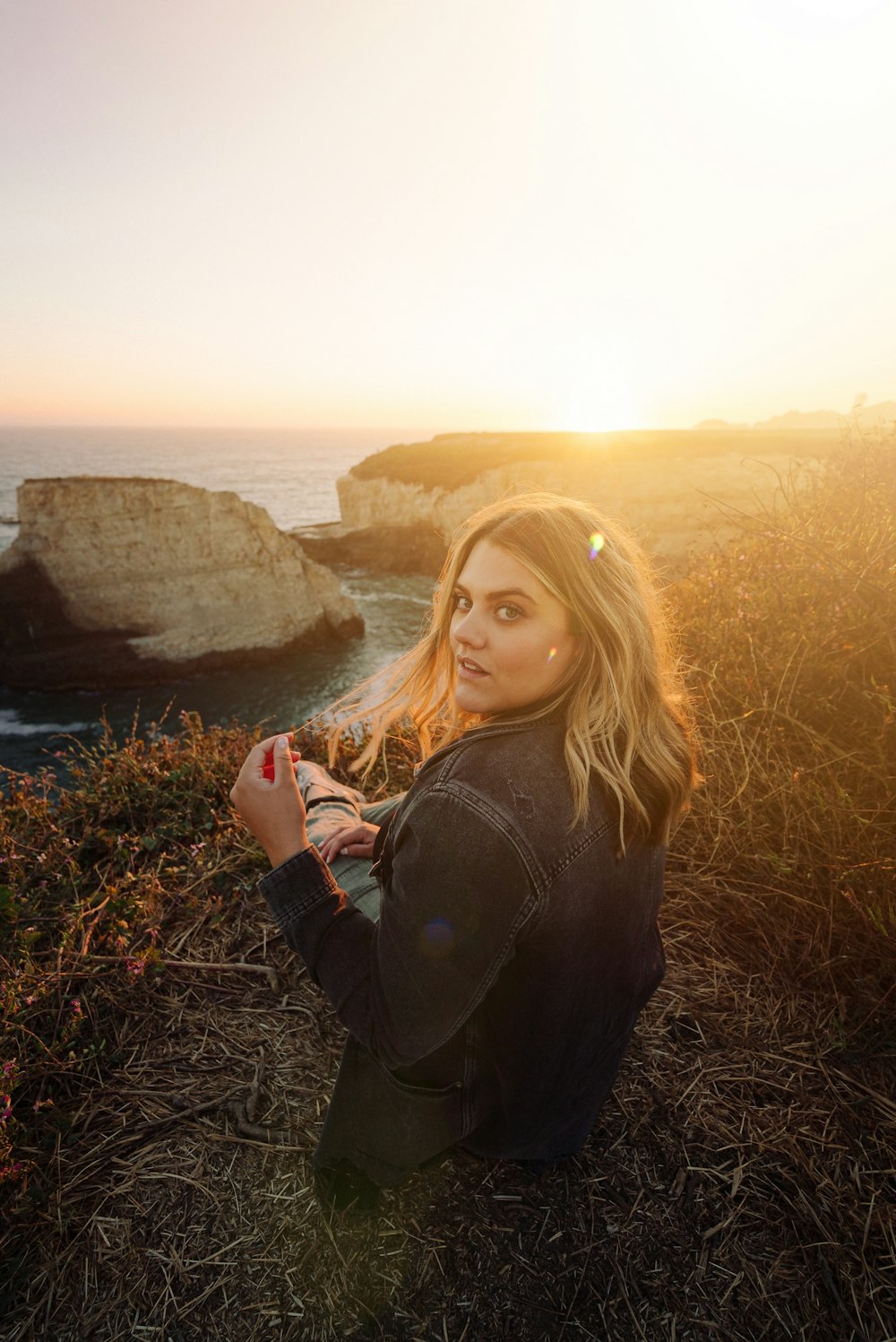 woman in black jacket standing on brown grass field during daytime