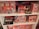 A showcase of cosmetic gift sets arranged on white shelves, featuring a range of products with vibrant retro packaging. The sets include various skincare and beauty items, each labeled with unique design and branding. The packaging has a vintage aesthetic with images and bold fonts.