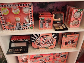 A showcase of cosmetic gift sets arranged on white shelves, featuring a range of products with vibrant retro packaging. The sets include various skincare and beauty items, each labeled with unique design and branding. The packaging has a vintage aesthetic with images and bold fonts.
