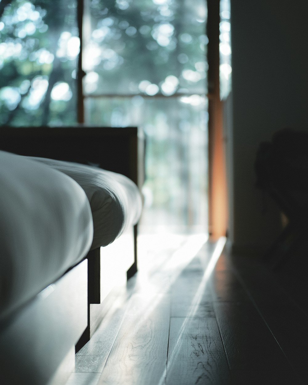 white bed near glass window