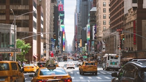 A bustling New York street filled with taxis and rideshare vehicles.