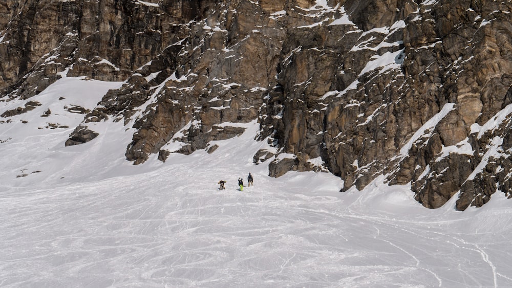 person in green jacket walking on snow covered ground during daytime