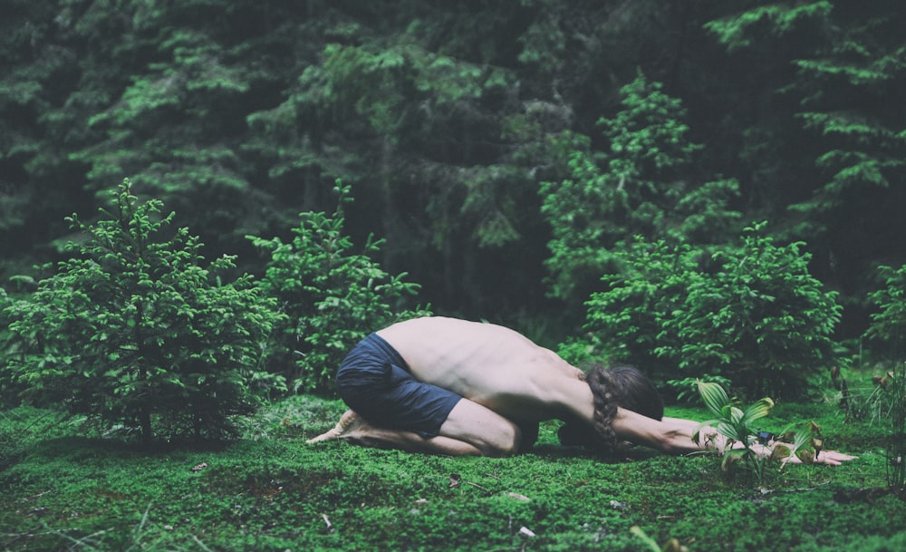 woman in black tank top and pink leggings doing yoga on green grass field during daytime