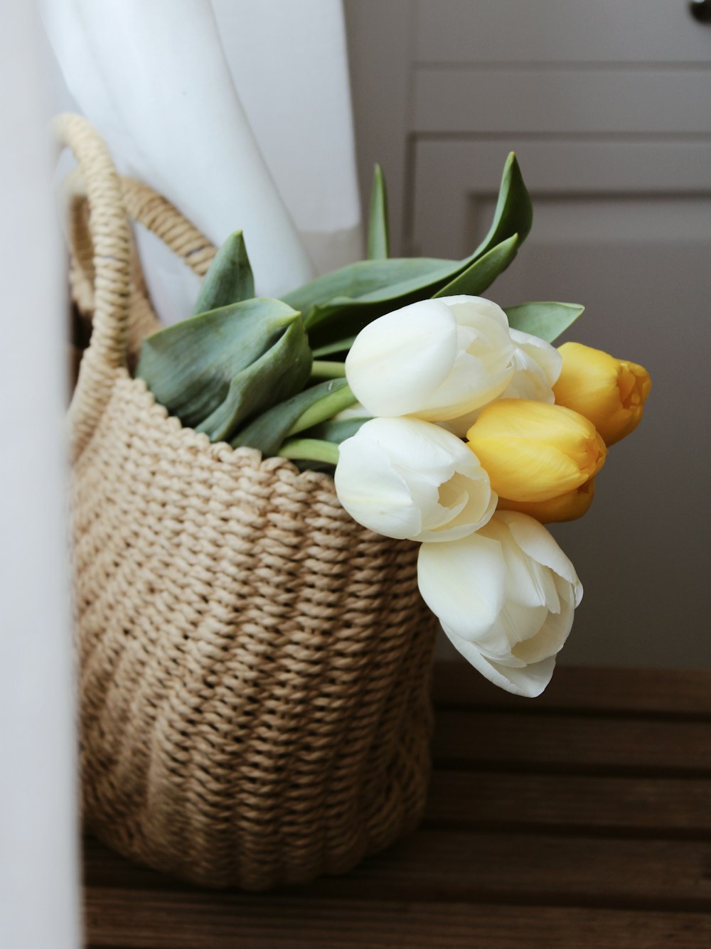 white and yellow flower on brown woven basket
