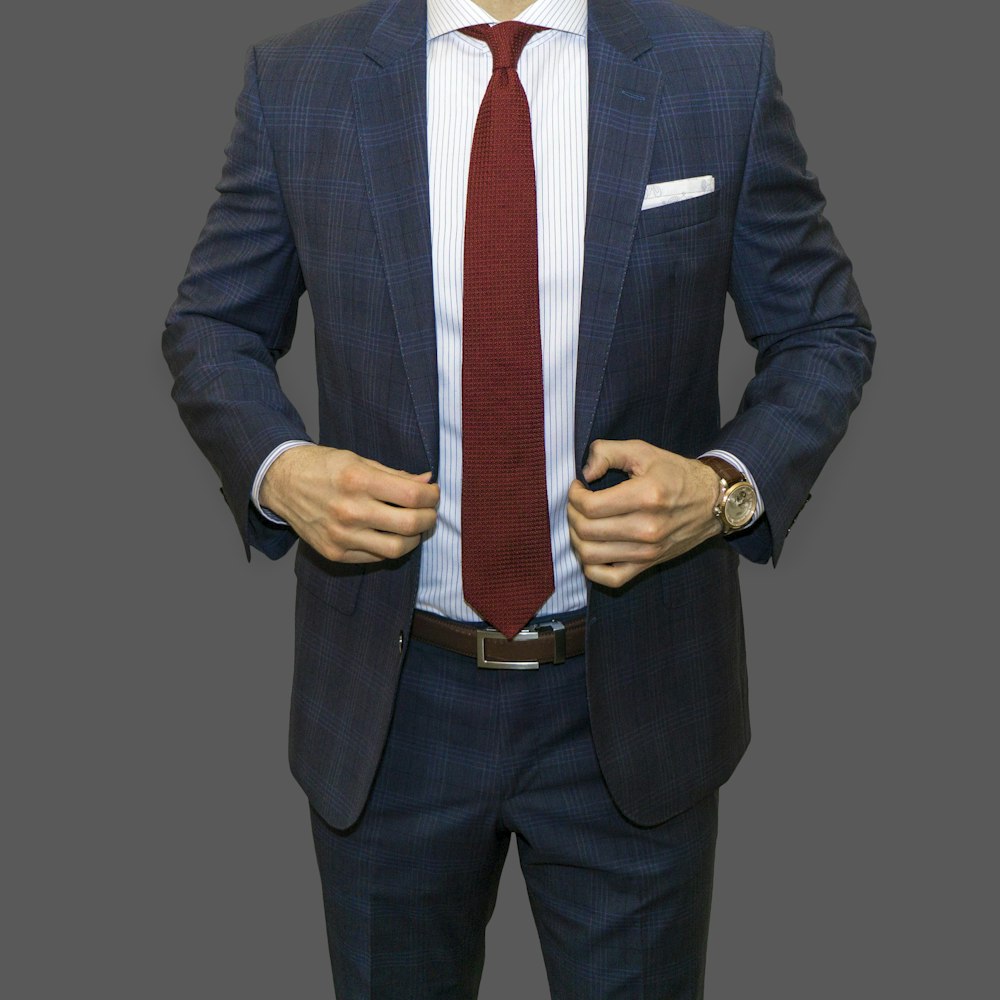Mann in schwarzer Anzugjacke und roter Krawatte