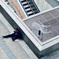 woman in black jacket and black pants lying on gray concrete stairs