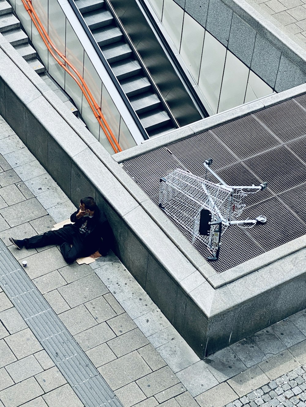 woman in black jacket and black pants lying on gray concrete stairs