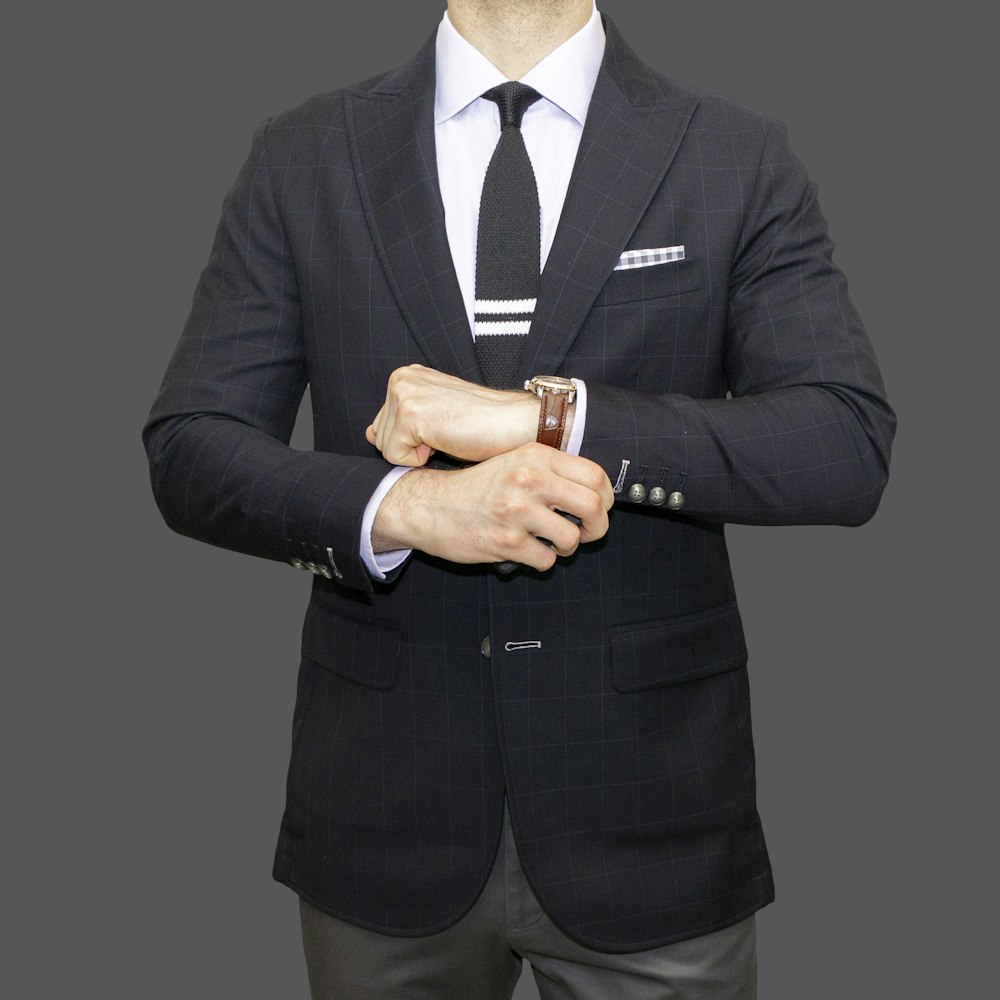 man in black suit jacket wearing gold watch