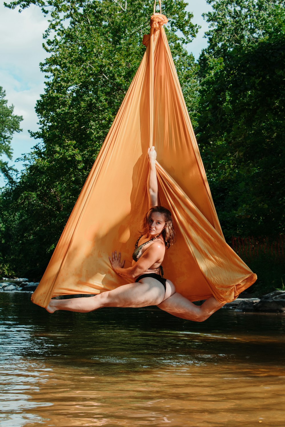 woman in black brassiere lying on orange hammock