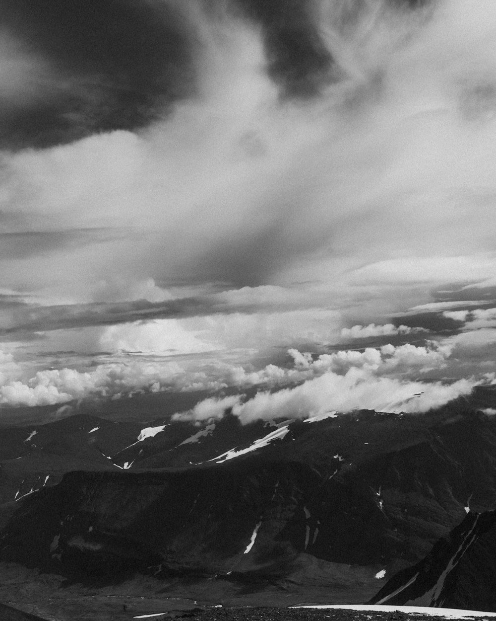 曇り空の下の山々のグレースケール写真