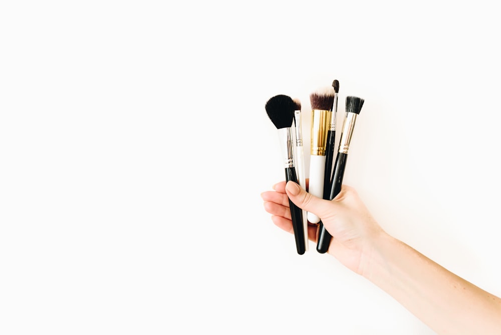 person holding black makeup brush