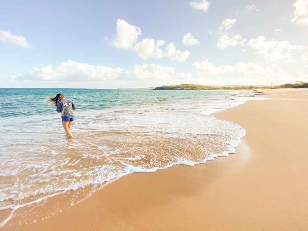 woman in blue bikini standing on beach during daytime