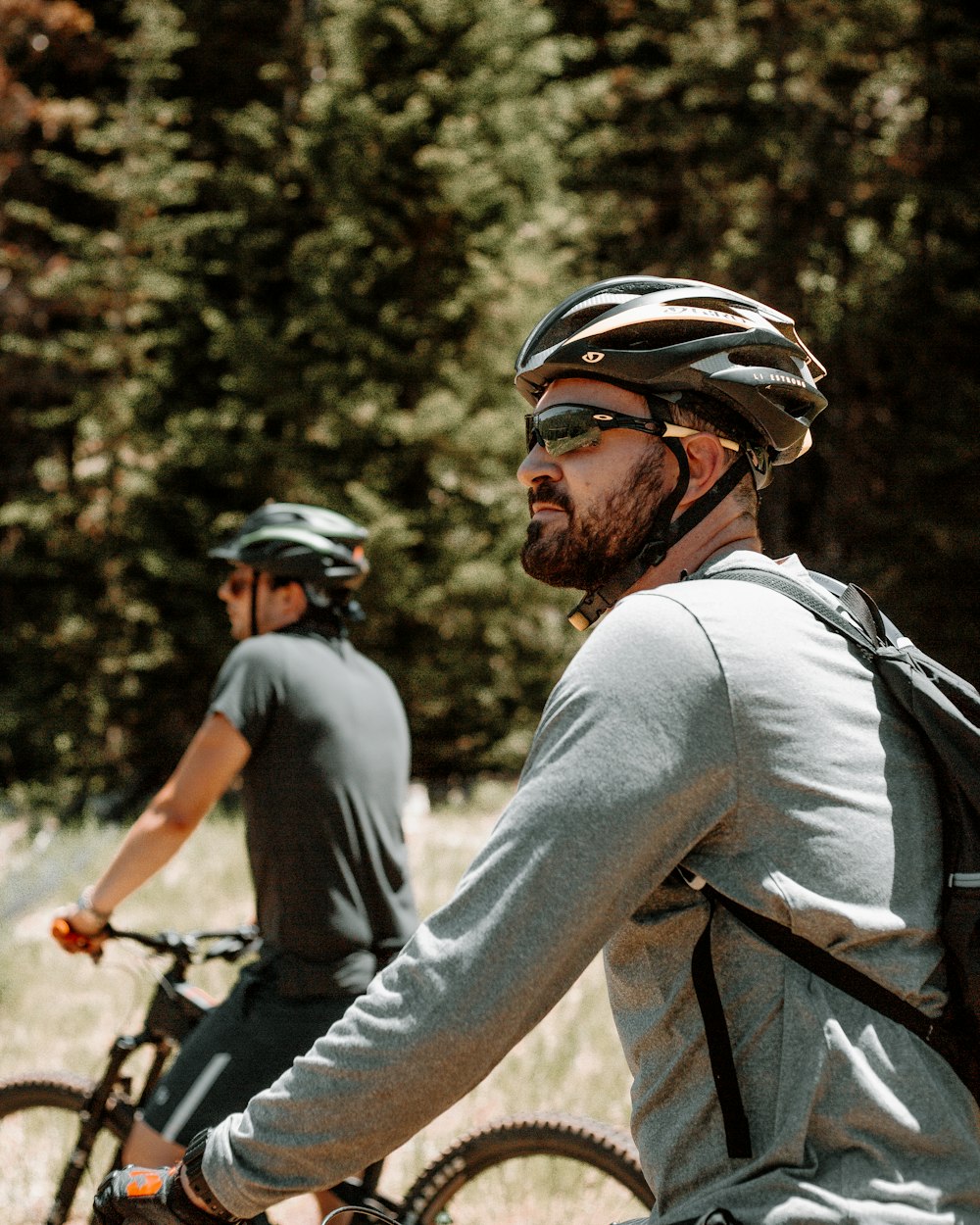 uomo in camicia grigia a maniche lunghe in bicicletta durante il giorno