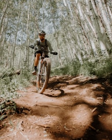 man riding on motorcycle in forest during daytime