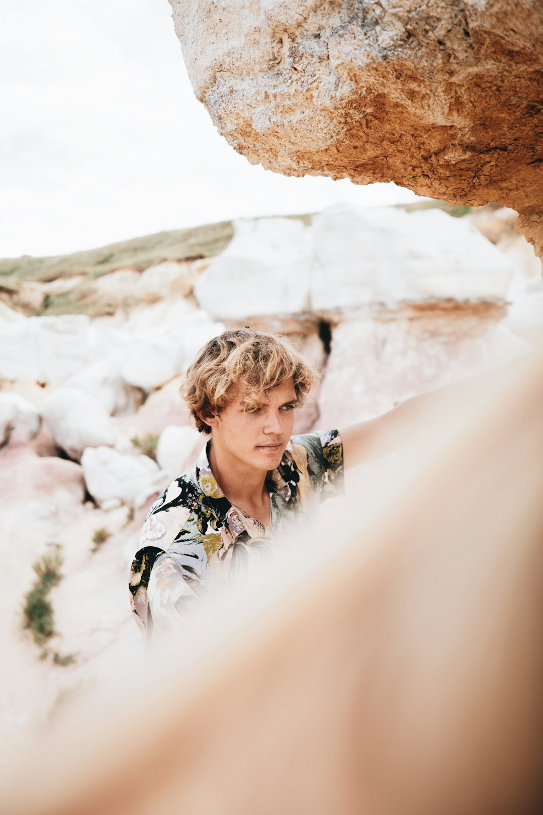 woman in black and white floral dress shirt standing on white rock