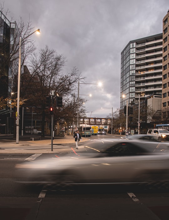 person in black jacket and black pants walking on sidewalk during daytime in Canberra ACT Australia