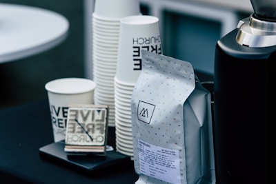 white and black ceramic mug beside white and black ceramic mug