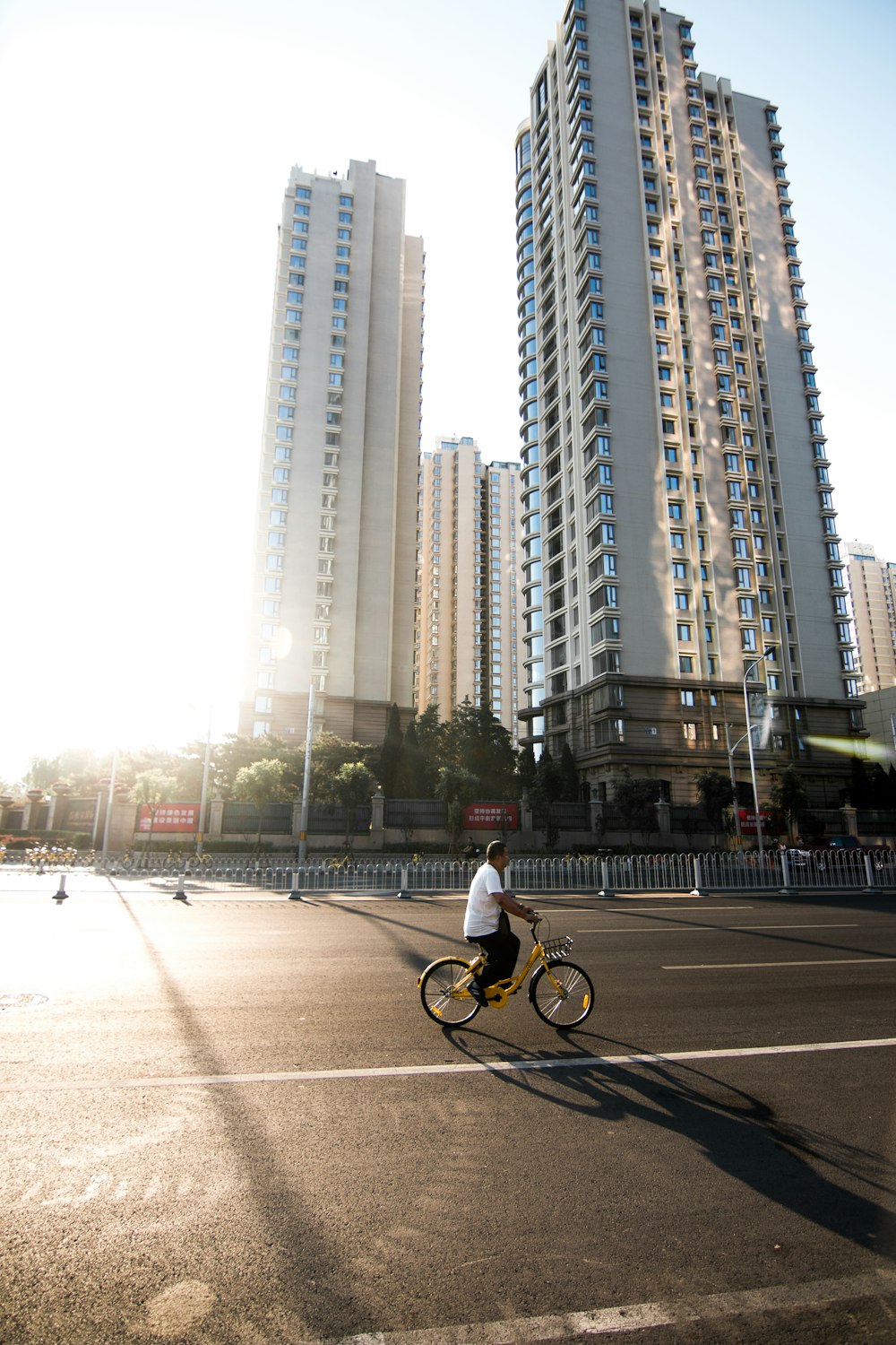 Mann im weißen Hemd fährt tagsüber Fahrrad auf der Straße