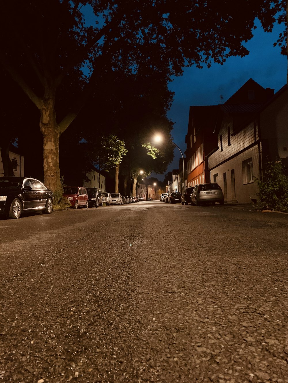 Coches aparcados a un lado de la carretera durante la noche
