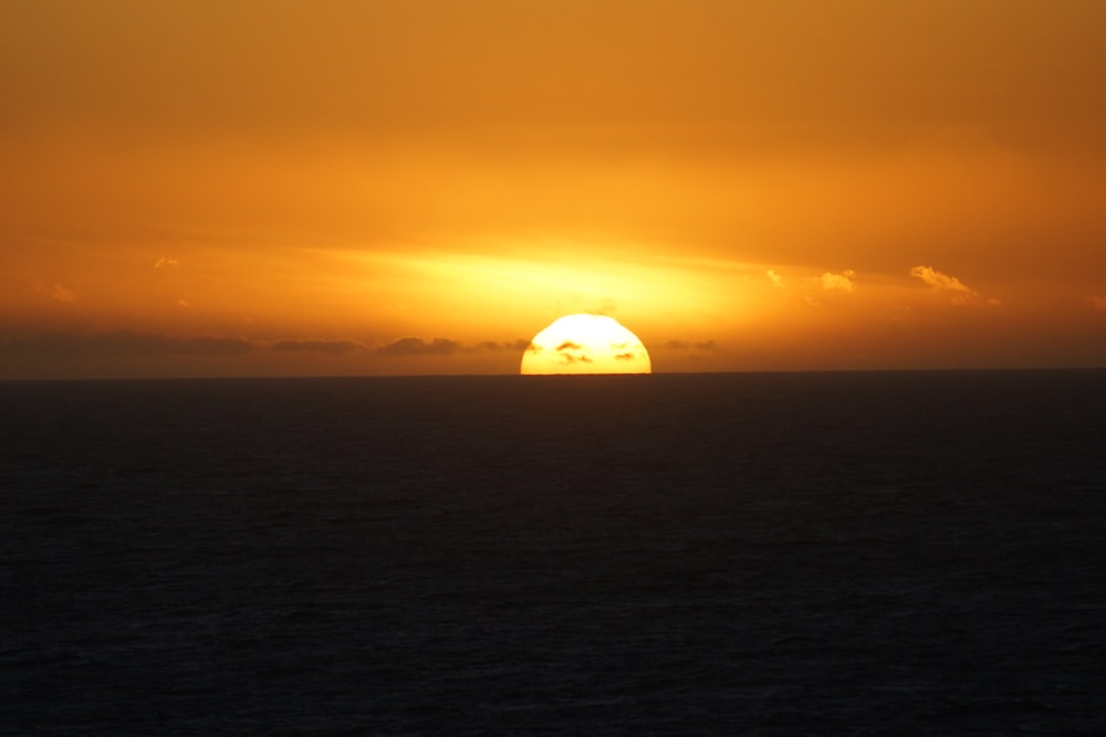 Silueta de una persona en un barco durante la puesta del sol