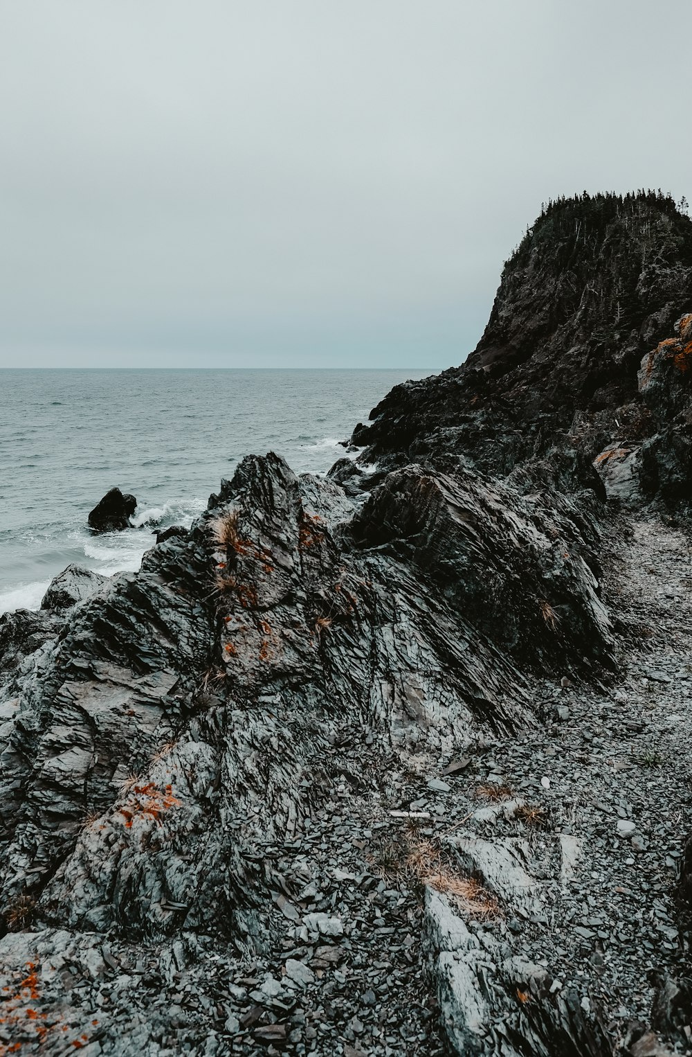 brown rock formation near body of water during daytime