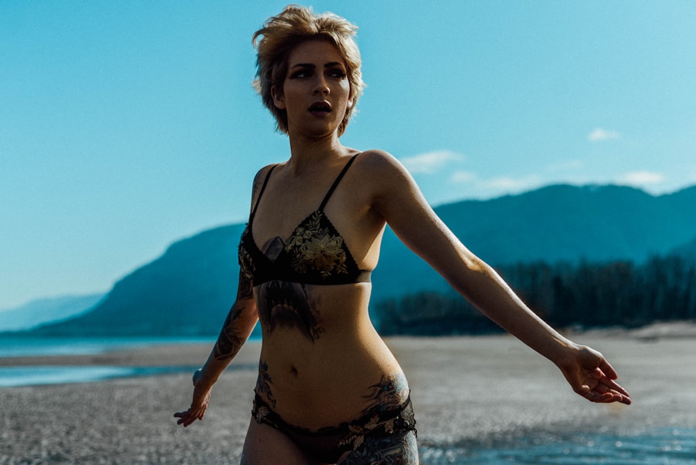 woman in black and white floral bikini standing on beach during daytime