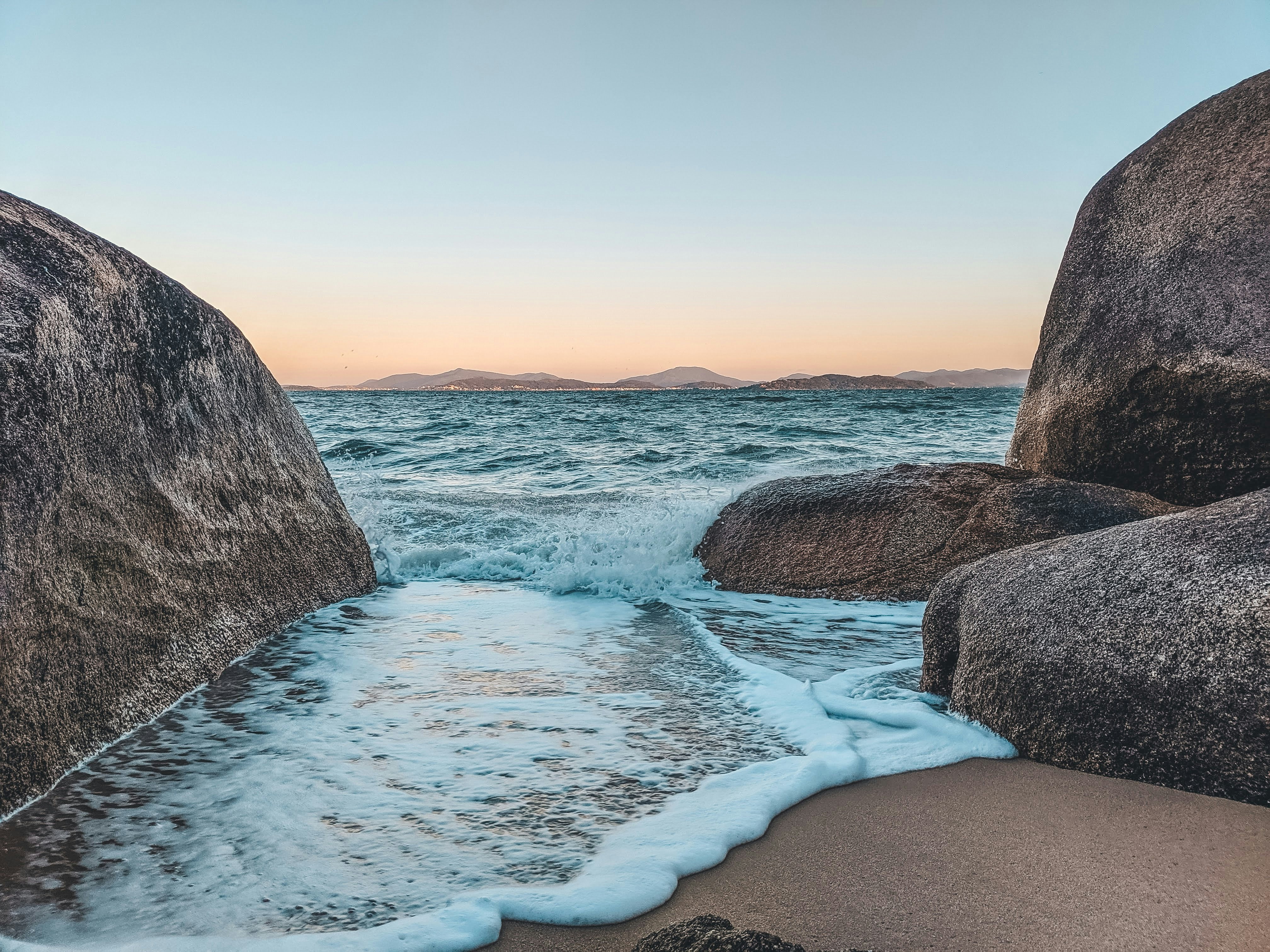 costa rocciosa con cielo blu e nuvole bianche