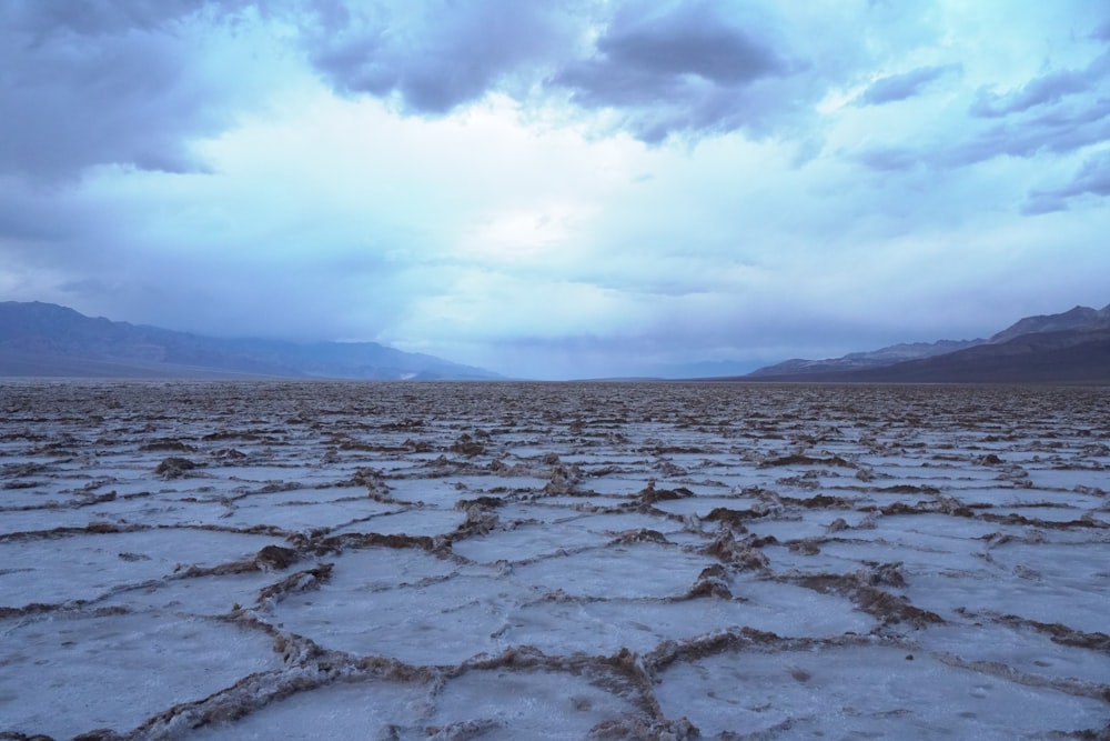 body of water under white clouds during daytime