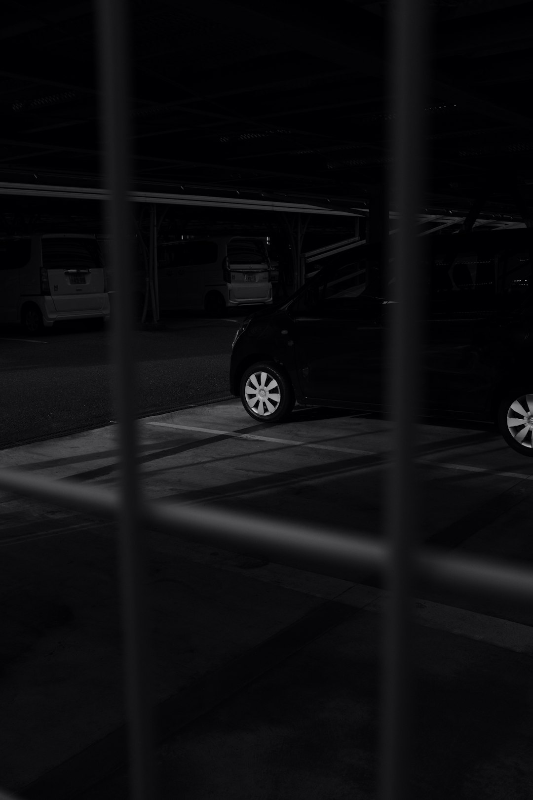 grayscale photo of car parked beside building