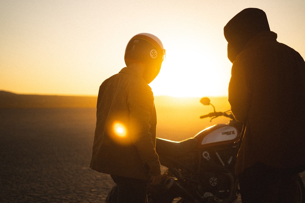 silhouette of man and woman riding motorcycle during sunset