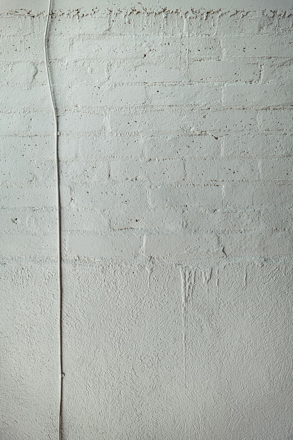 白いコンクリートの壁に白いコーティングされたワイヤー