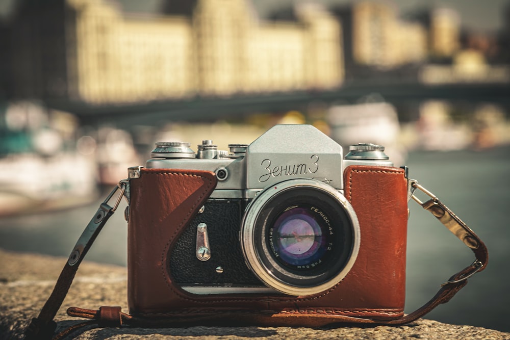 câmera nikon dslr vermelha e prateada na mesa de madeira marrom