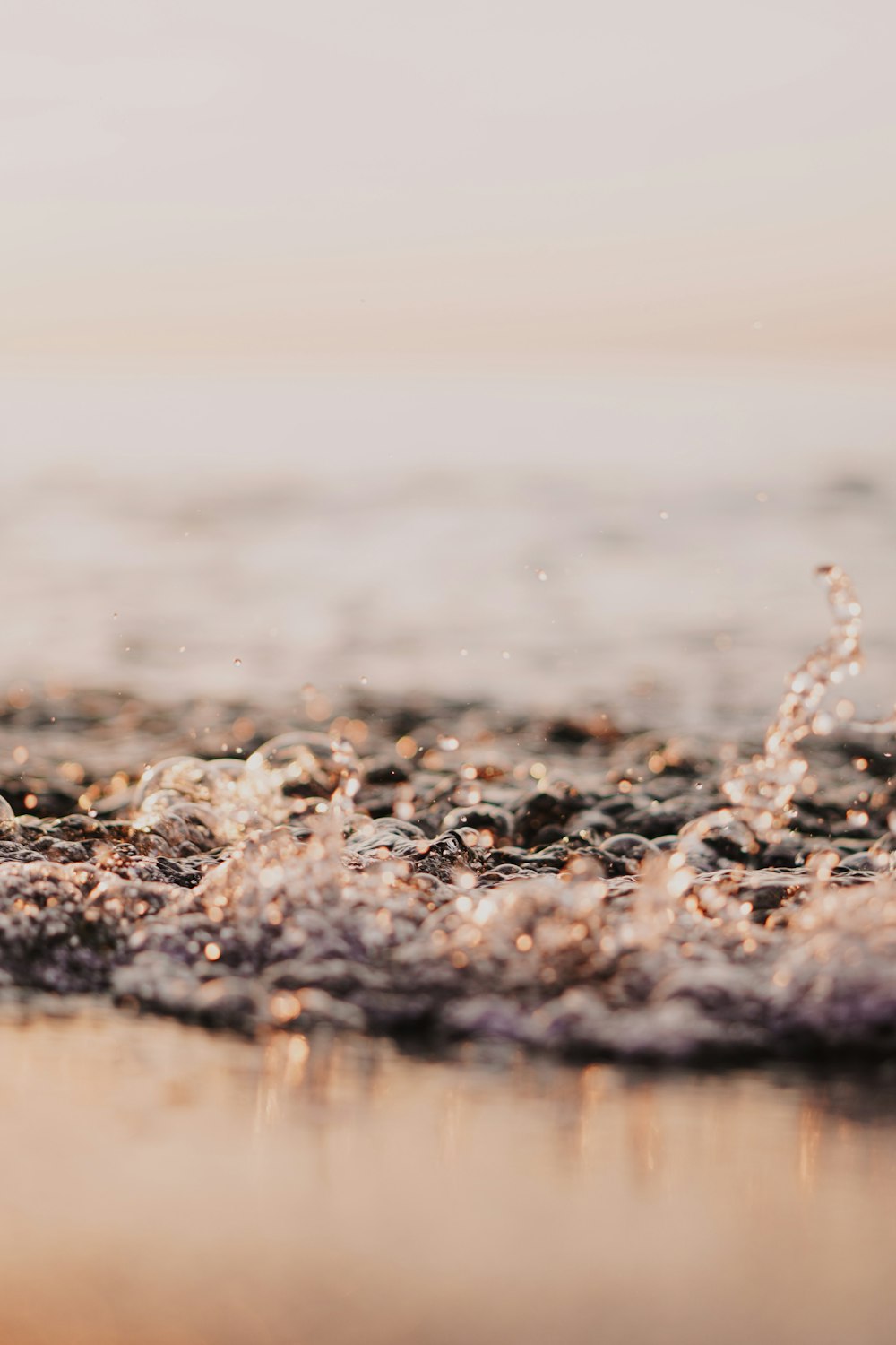 water splash on brown sand during daytime