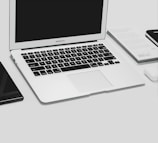 A MacBook Air opened up on the repair bench showing a clean workspace and tools.