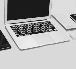 A MacBook Air opened up on the repair bench showing a clean workspace and tools.