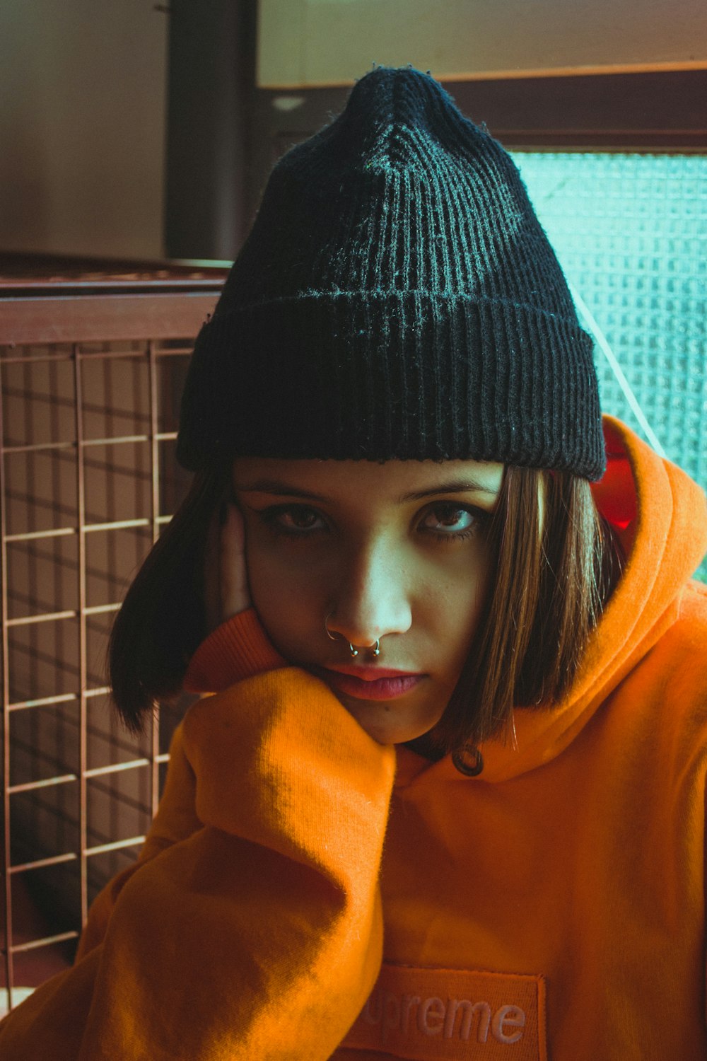 woman in black knit cap and orange hoodie