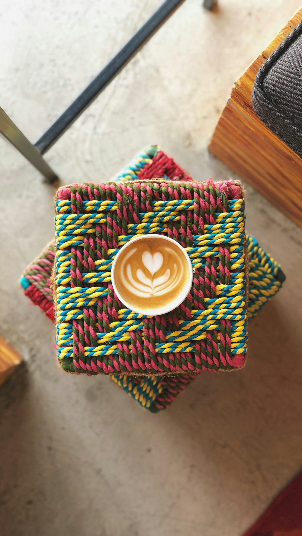 white ceramic cup on green and yellow knit textile