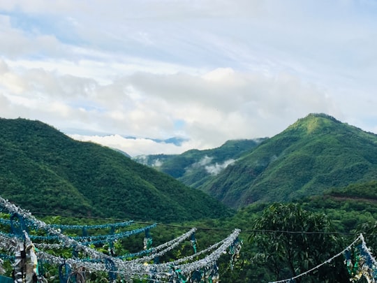 green mountains under white clouds during daytime in Narendranagar India