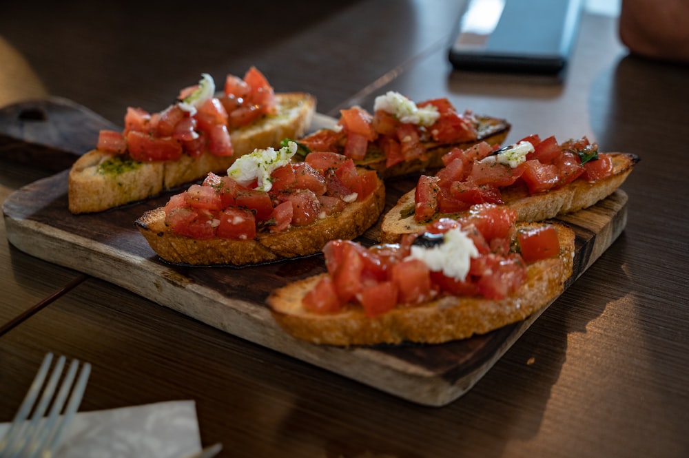 brown bread with tomato and green vegetable on brown wooden table