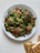 A plate of golden-brown meatballs garnished with fresh parsley and a side of marinara sauce.