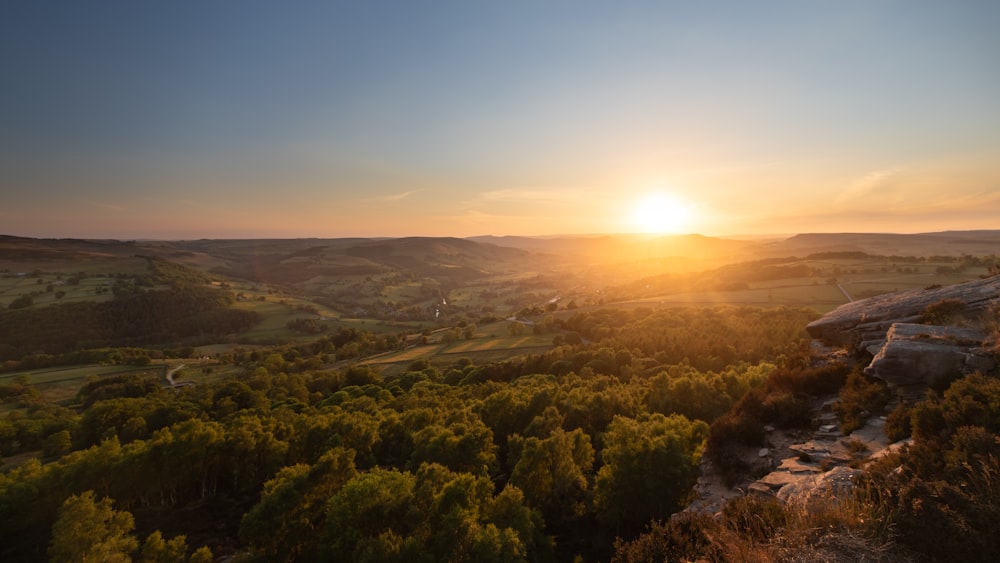 Árboles verdes y montañas durante la puesta de sol